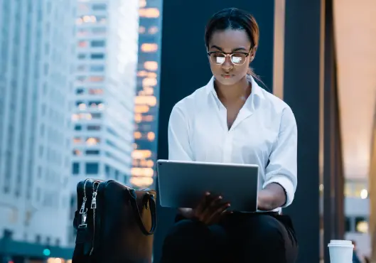 female browsing tablet while sitting on bench 
