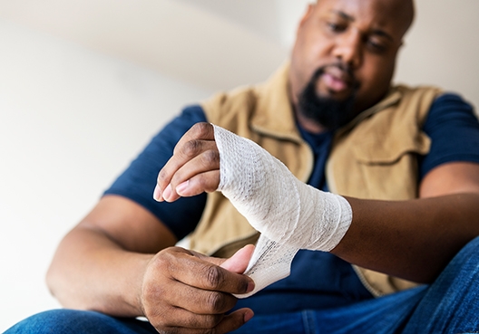 A worker bandaging his wrist