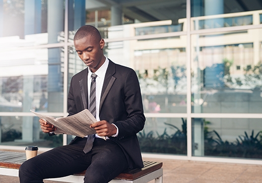 A guy sitting on a bench reading