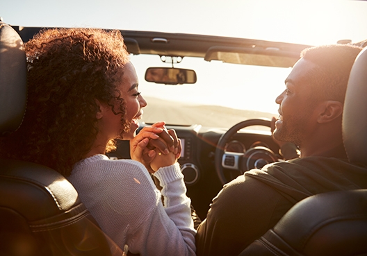 couple holding hands in the front seat of a car