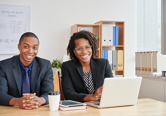 two colleagues sitting side by side at a conference table