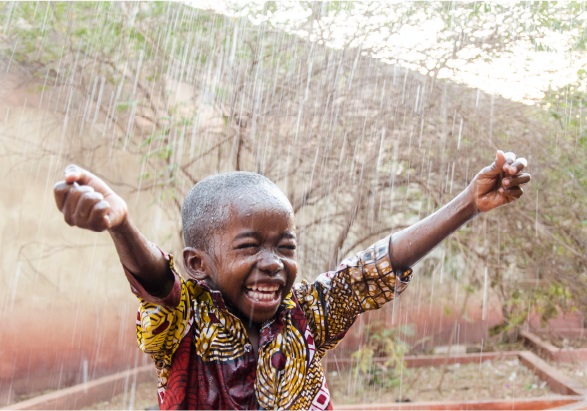 kid smiling in the rain