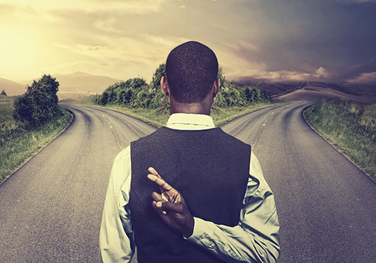 A young man standing at a crossroads