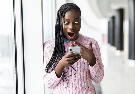 Young girl looking at her phone with a shocked face