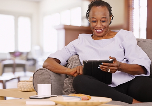 woman sitting on couch reading her tablet