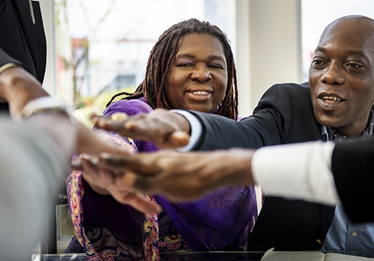 A group of people all putting their hands in for a high frive