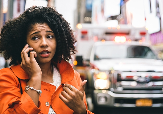 woman talking on her phone at the scene of an accident