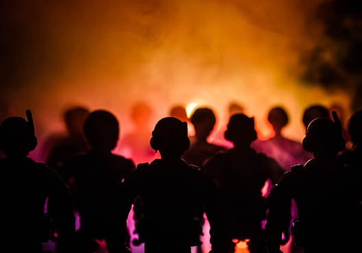 man crouching beside his desk talking on a landline