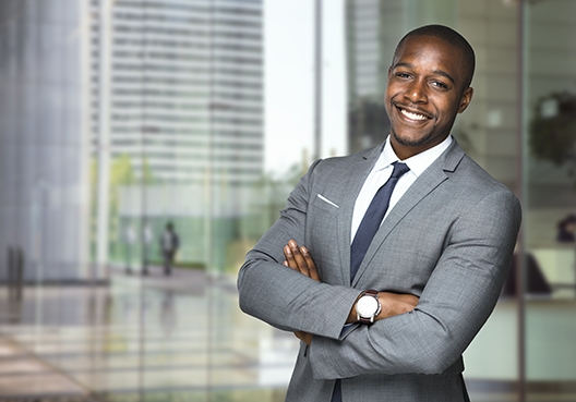 man standing in suit with his arms crossed