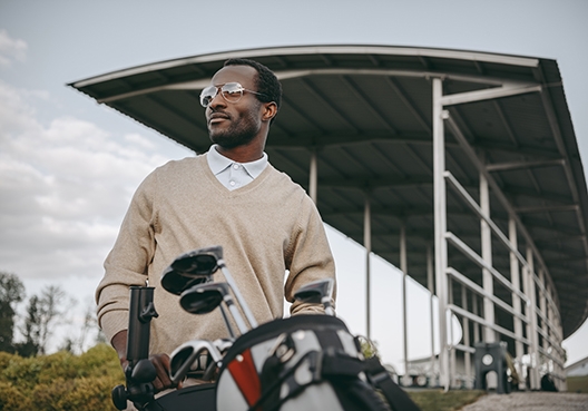Golfer standing with his carry bag