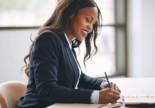 woman sitting at her desk making notes
