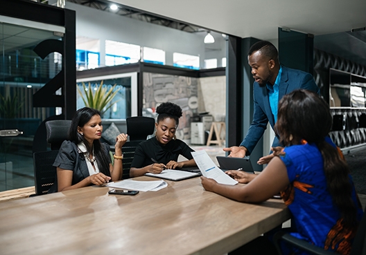group of people sitting together around a conference table working