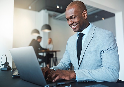man working on his laptop smiling