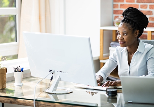 working sitting at her desk working on her laptop
