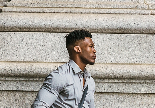 A man wearing a grey shirt walks to a UAP Old Mutual branch.