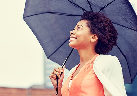 woman walking outside with an umbrella over her head