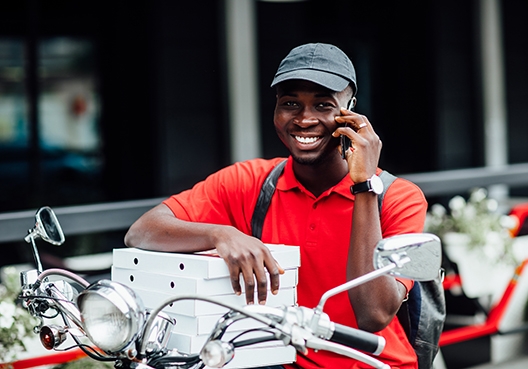 young man sitting on his motorcycle talking on his cellphone